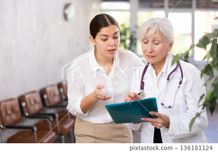 Woman consults with a doctor about the diagnosis and treatment of disease 136181124