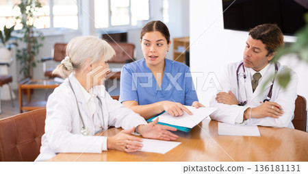Young female doctor conducting medical council with experienced colleagues Young female doctor conducting medical council with experienced colleagues 136181131