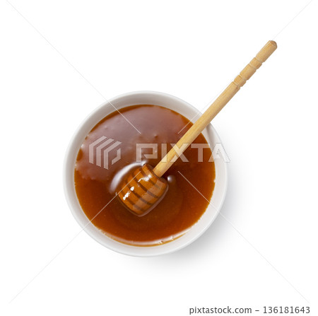Manuka honey in a white container and honey dipper, viewed from above Manuka honey in a white container and honey dipper, viewed from above 136181643