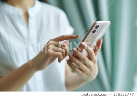 Woman's hand operating a smartphone Generative AI 136181777