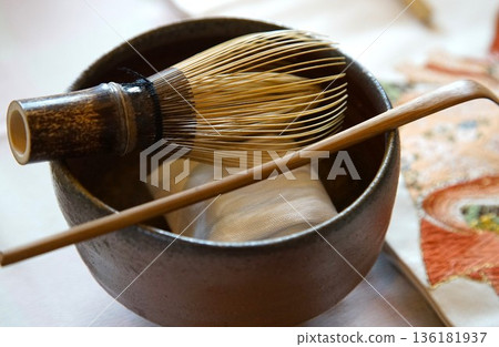 一個竹製茶筅和茶匙連在一個茶碗上。 136181937