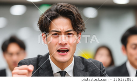 A Japanese businessman explodes with frustration and yells violently 136182093