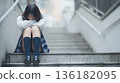 A Japanese female student crouches on the stairs, rejecting the outside world 136182095