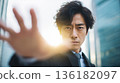A Japanese man reaching out towards the light, trying to grab something 136182097