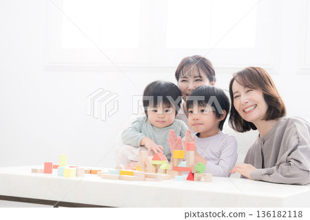 祖孫三代,祖母、母親和孩子麵帶笑容地玩著積木,這是一張父母與孩子幸福的合影,照片中還有兩個孩子(孫子)和兄弟姊妹。 祖孫三代,祖母、母親和孩子麵帶笑容地玩著積木,這是一張父母與孩子幸福的合影,照片中還有兩個孩子(孫子)和兄弟姊妹。 136182118