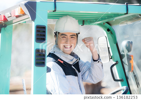 Close-up of a worker carrying lumber with a forklift, fist pump Close-up of a worker carrying lumber with a forklift, fist pump 136182253