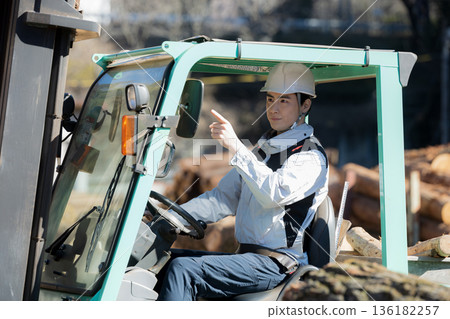 A worker transporting lumber with a forklift - safety check "All right!" Close-up A worker transporting lumber with a forklift - safety check "All right!" Close-up 136182257