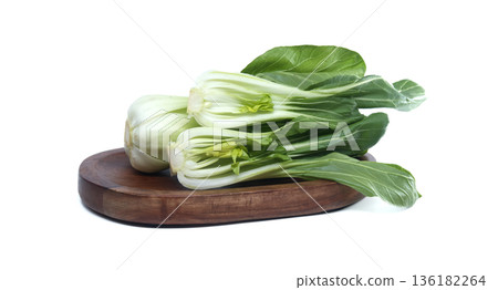 Fresh bok choy vegetables arranged on a wooden board against a white background Fresh bok choy vegetables arranged on a wooden board against a white background 136182264