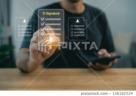 Man using e-signature on digital tablet for electronic document signing. Virtual screen showing online contract, digital signature technology, paperless office, and remote authentication. 136182524