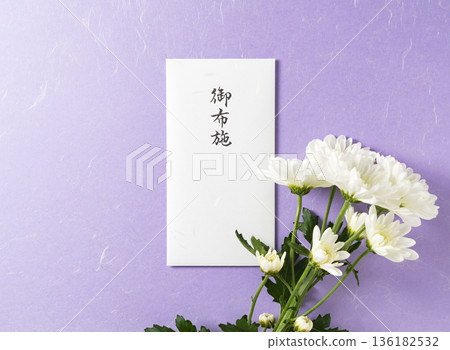 紫色日式紙背景上的「供奉」信封和白色菊花（佛教儀式或葬禮的圖片） 136182532
