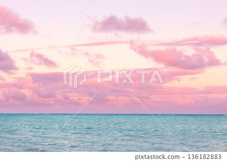 Tropical sunset with pink cloudy sky and peaceful water. 136182883