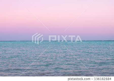 Tropical sunset with pink cloudy sky and peaceful water. Tropical sunset with pink cloudy sky and peaceful water. 136182884