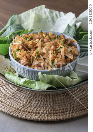 Homemade fermented pork and Thai crispy fried rice salad, featuring crispy fried rice balls served with wild betel leaves (cha-plu leaves), ginger, peanuts, and lime juice. 136183069