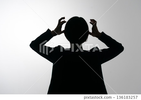 Silhouette of a woman holding her head Silhouette of a woman holding her head 136183257