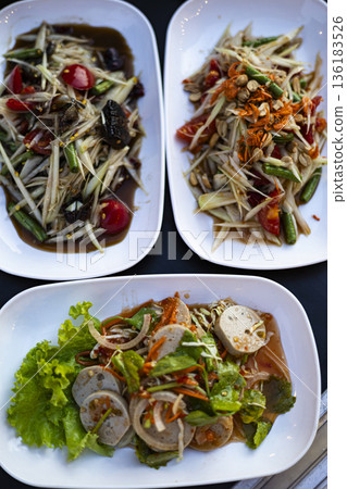 Thai Papaya Salad Set With Crab Fish Sauce And Vietnamese Sausage Yum Ready To Serve, A documentary shot of papaya salad on table, fresh lime and herbs beside, for local food or spicy showcase. Thai Papaya Salad Set With Crab Fish Sauce And Vietnamese Sausage Yum Ready To Serve, A documentary shot of papaya salad on table, fresh lime and herbs beside, for local food or spicy showcase. 136183526