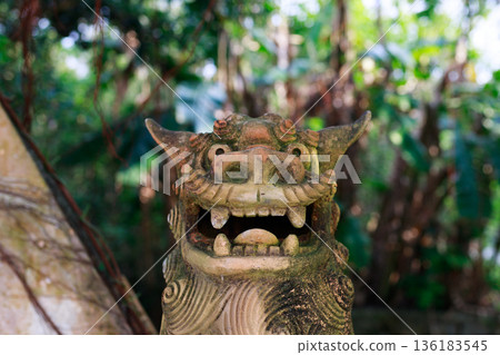 Okinawan Shisa statue standing in the forest Okinawan Shisa statue standing in the forest 136183545