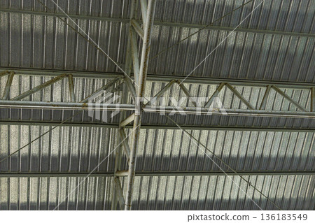 Under Large Steel Roof Structure, A grand photo of under large steel structure, massive beams and trusses towering in light on concrete floor, for modern architecture or engineering documentary. Under Large Steel Roof Structure, A grand photo of under large steel structure, massive beams and trusses towering in light on concrete floor, for modern architecture or engineering documentary. 136183549