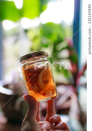 一瓶手工糖漿在自然光下閃閃發光 136183940