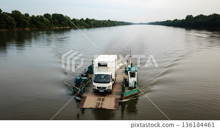 White Commercial Truck Being Ferried Across A River With Green Trees On A Bright Day 136184461