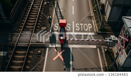 Aerial View of Red Motorcycle at Railway Crossing with Stop Sign and White X Marking 136184483