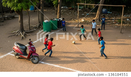 Children Soccer Match on Sandy Field with Scooter and Trees under Sunlight 136184551