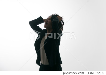 A woman in a suit messing up her head A woman in a suit messing up her head 136187218