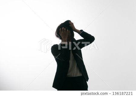 A woman in a suit messing up her head A woman in a suit messing up her head 136187221