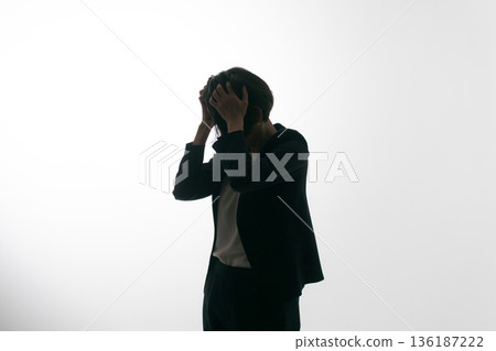 一個穿著西裝的女人把頭弄亂了。 一個穿著西裝的女人把頭弄亂了。 136187222