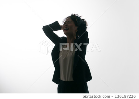 A woman in a suit messing up her head A woman in a suit messing up her head 136187226