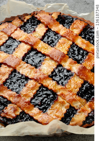 Freshly baked berry pie with a golden crust and a crispy lattice top at a kitchen counter 136187348