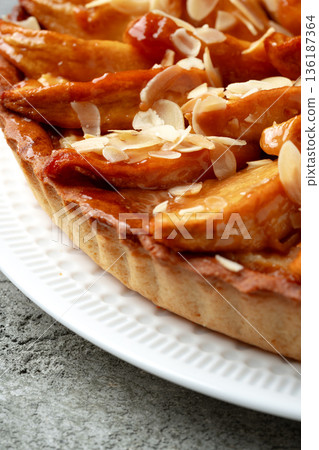 Dessert dish with baked apples and almond slices on white plate 136187364