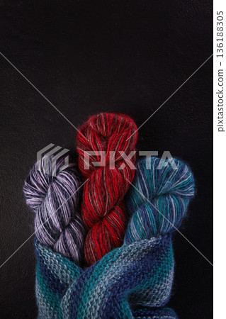 There are skeins of multicolored wool yarn on the table. Yarn for knitting warm clothes. The concept of hobbies and handicrafts. Top view. 136188305