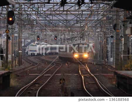 黃昏時分,一列223系列車駛近茨城站。 黃昏時分,一列223系列車駛近茨城站。 136188568