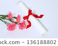 Pink carnations and a diploma tied with a red ribbon 136188802
