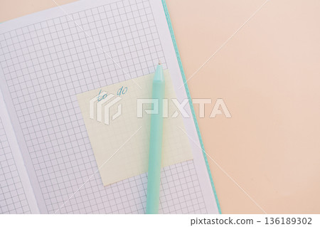 Sticky note with to do words on grid notebook and mint pen, pastel workspace 136189302