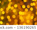Golden bokeh lights with warm glow and blurred sparkling circles on dark background 136190265