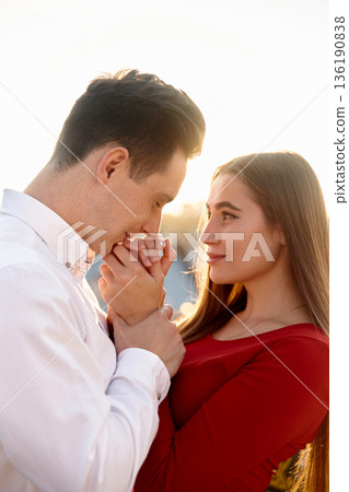 Couple enjoying a moment together with sunlight shining in the background during a warm evening 136190838