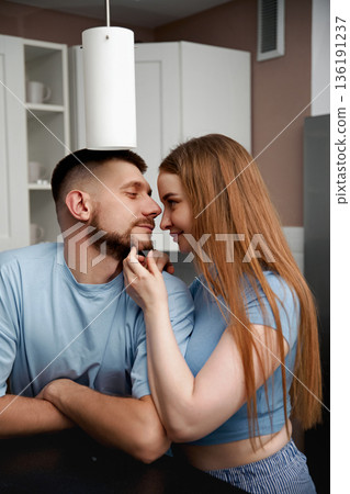 Romantic couple sharing intimate moment in modern kitchen, showcasing love and connection in a cozy atmosphere, relationship goals, affectionate bond, healthy relationship concept 136191237