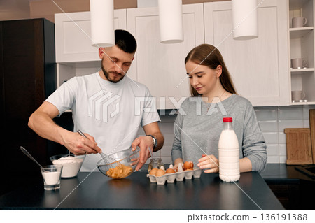 Young Couple Prepares Breakfast Together in a Modern Kitchen During a Sunny Morning Young Couple Prepares Breakfast Together in a Modern Kitchen During a Sunny Morning 136191388