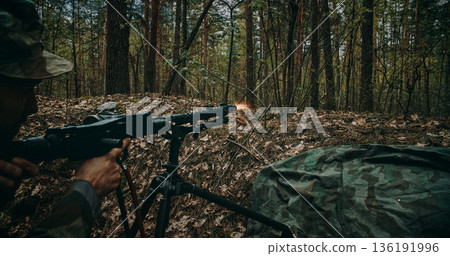 Wehrmacht machine gunner firing MG34 in forest trench during WWII battle 136191996
