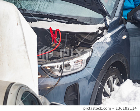 Car is being jump started in snowy weather in winter season during daylight hours Car is being jump started in snowy weather in winter season during daylight hours 136192114