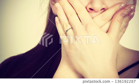 Woman covering her mouth with hand 136192287