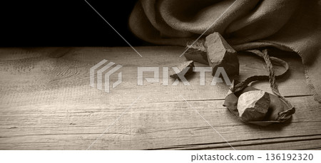 An antique leather sling lies on wooden desk An antique leather sling lies on wooden desk 136192320