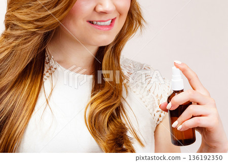 Woman applying hair cosmetic Woman applying hair cosmetic 136192350
