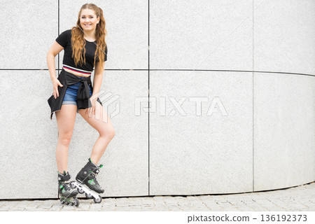 Young woman riding roller skates 136192373