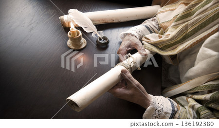 Man holding an old scroll Man holding an old scroll 136192380