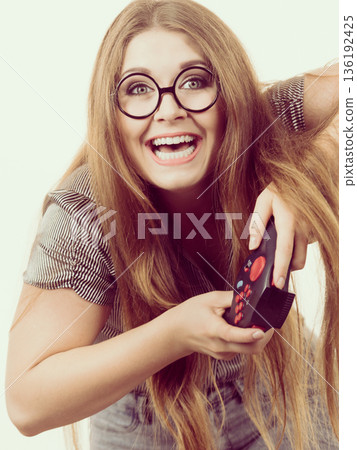 Gamer woman holding gaming pad Gamer woman holding gaming pad 136192425