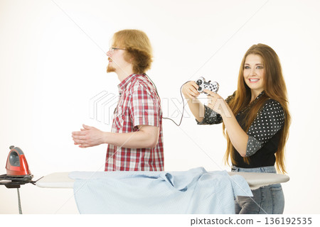 Woman controling man to do ironing Woman controling man to do ironing 136192535