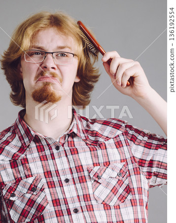 Man having problem with brushing hair 136192554
