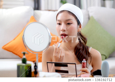 Beauty happy young asian woman applying makeup with lipstick looking mirror. 136192712